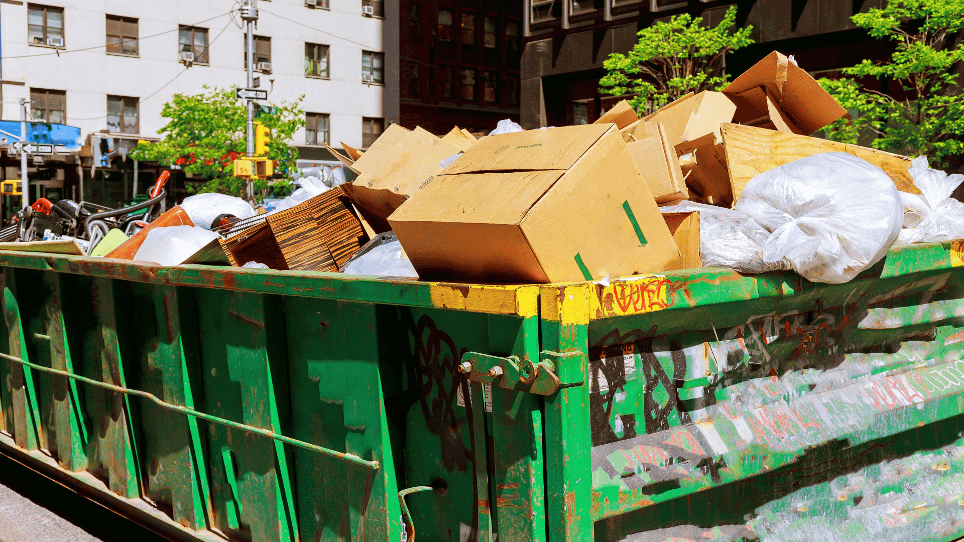 large dumpster filled with cardboard boxes and junk removal debris