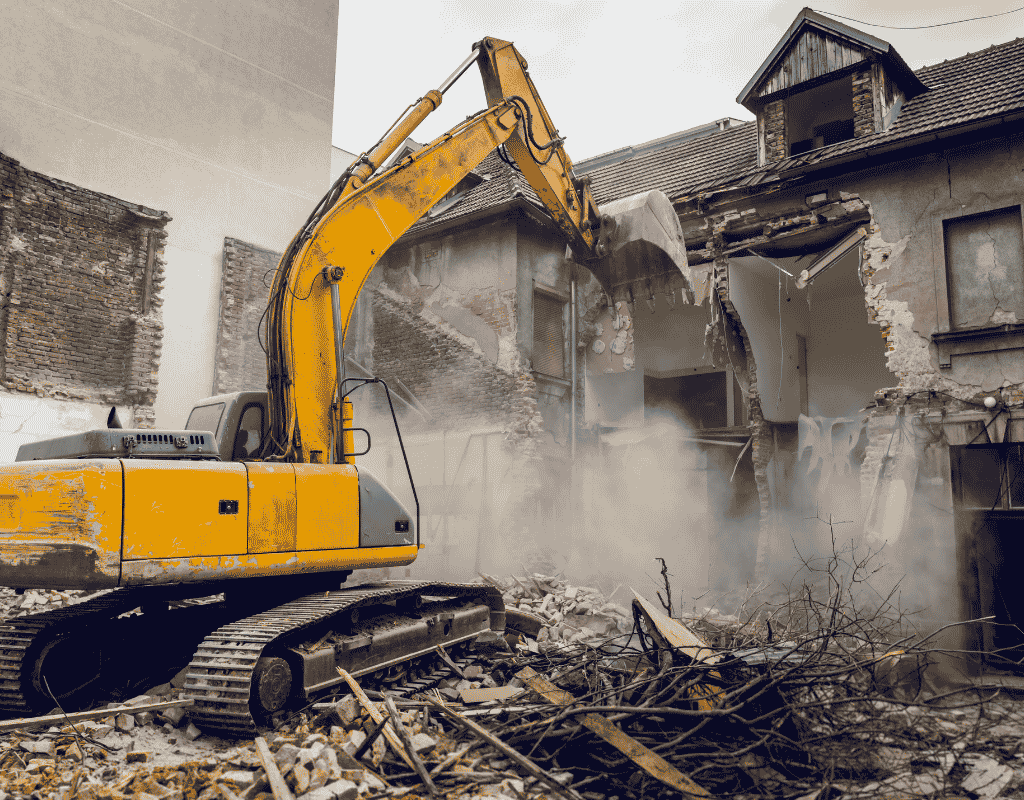excavator demolishing old residential structure with debris removal