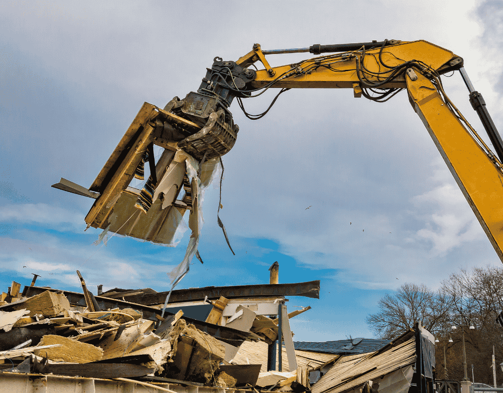 heavy equipment removing demolition debris from construction site