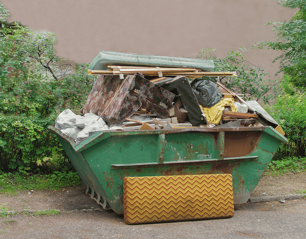 green dumpster filled with renovation debris and household waste